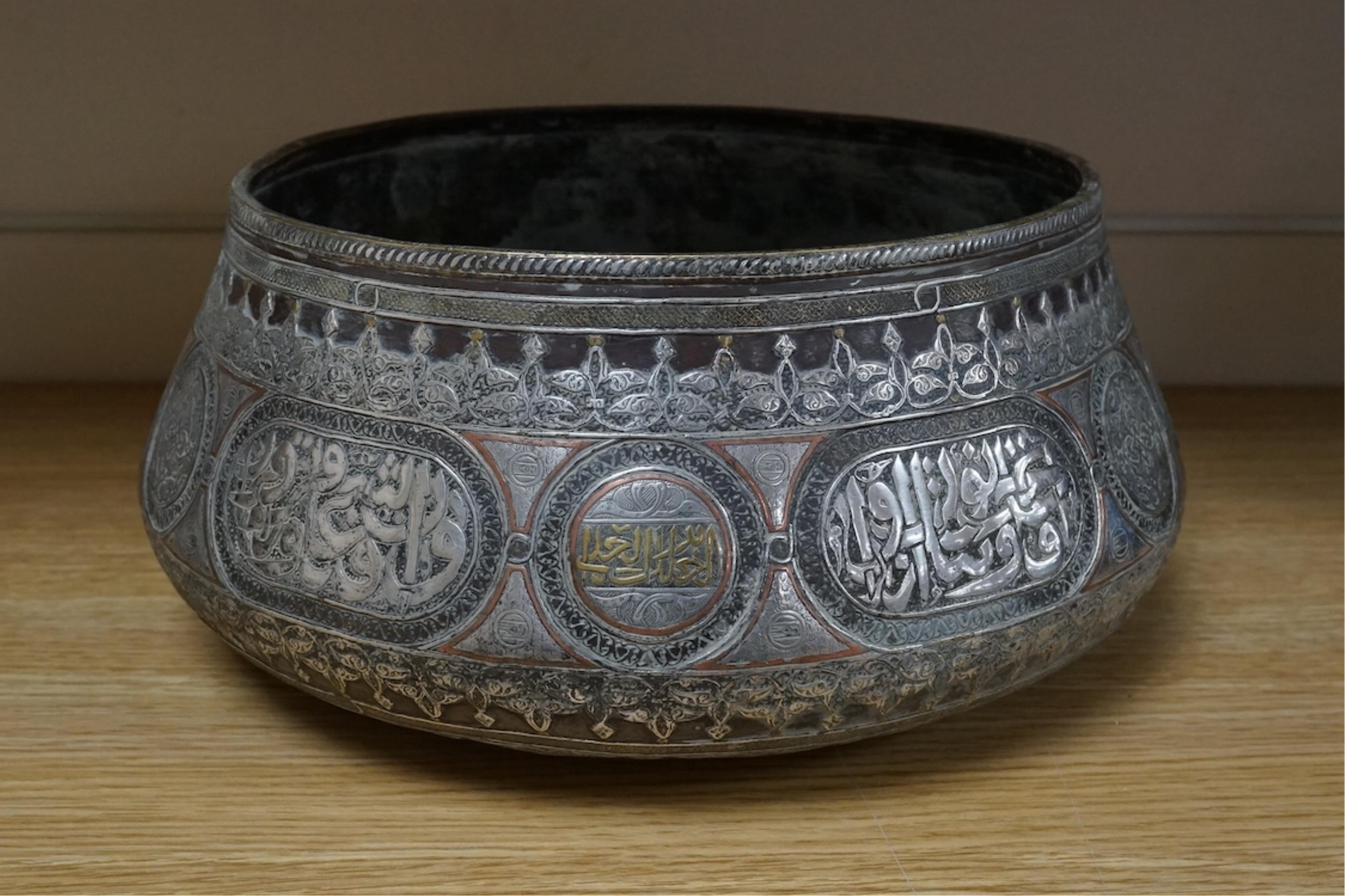 A late 19th century Mamluk style brass basin inlaid with silver and copper decoration, 29cm diameter